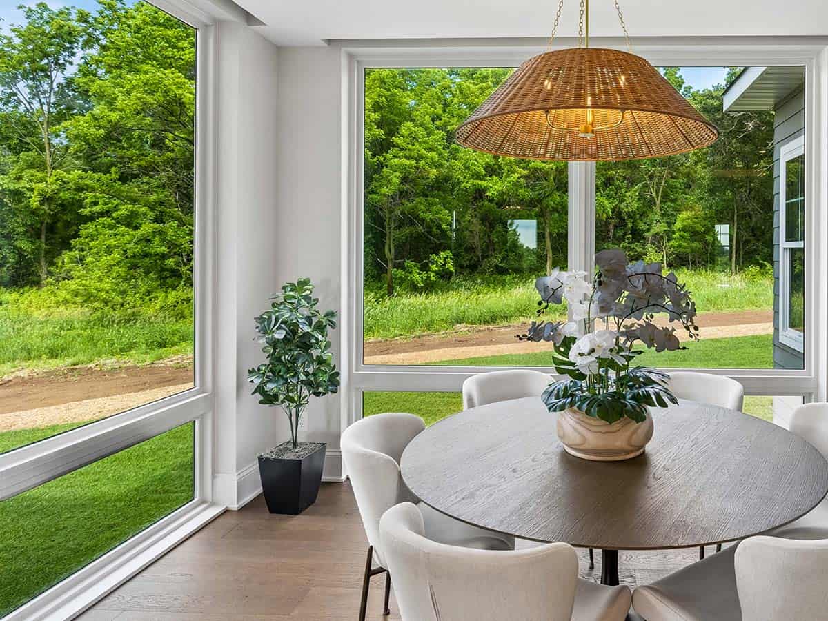 Sunroom dining area with round table and floor-to-ceiling windows