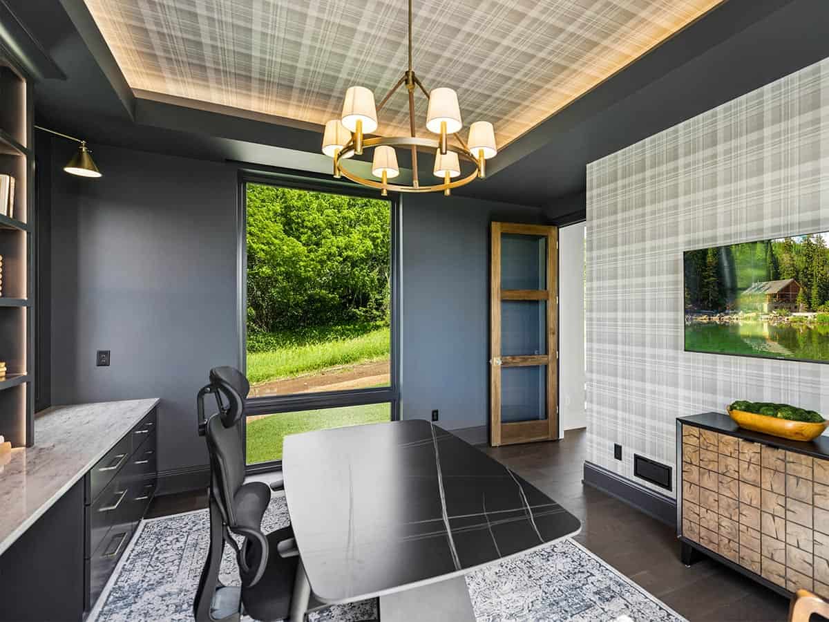 Home office with plaid wallpaper accent wall and brass chandelier
