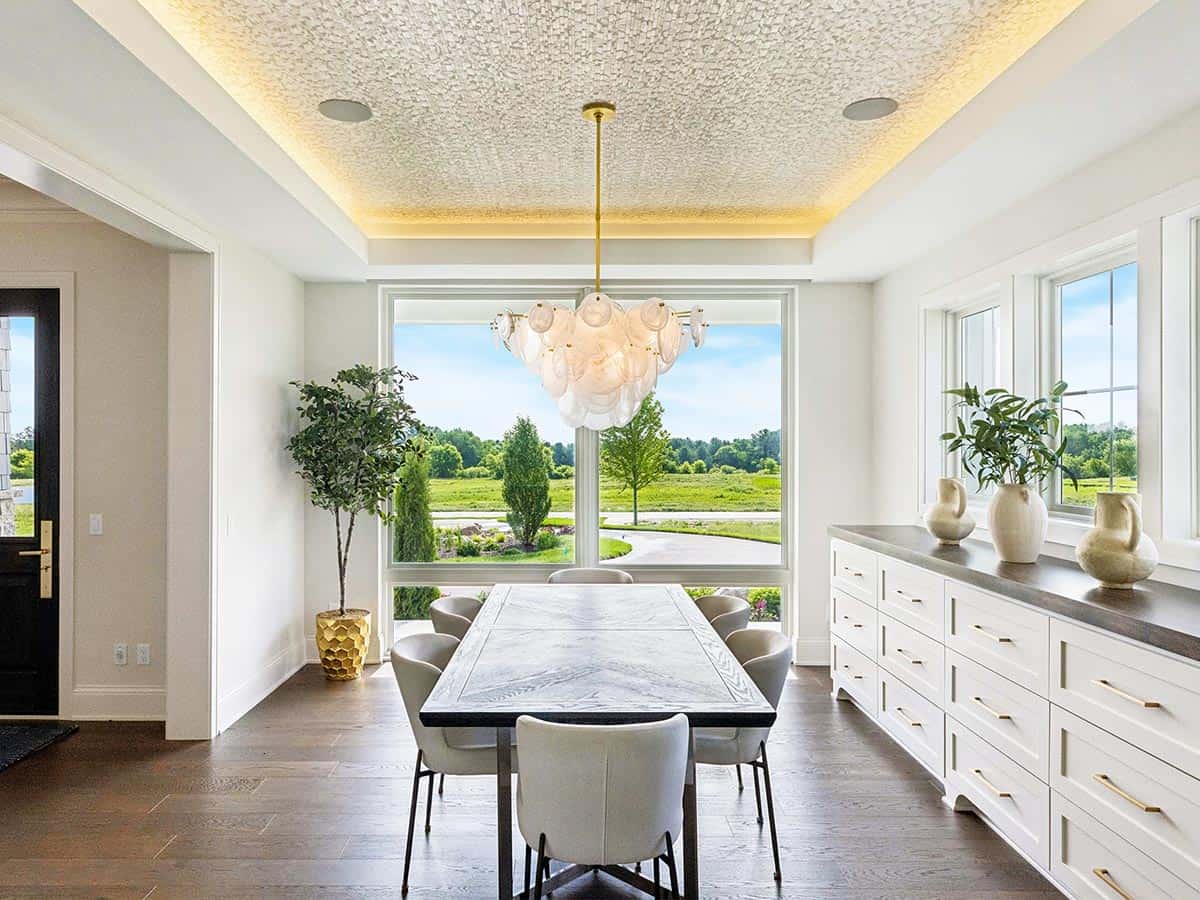 Dining room with long table and white drum chandelier