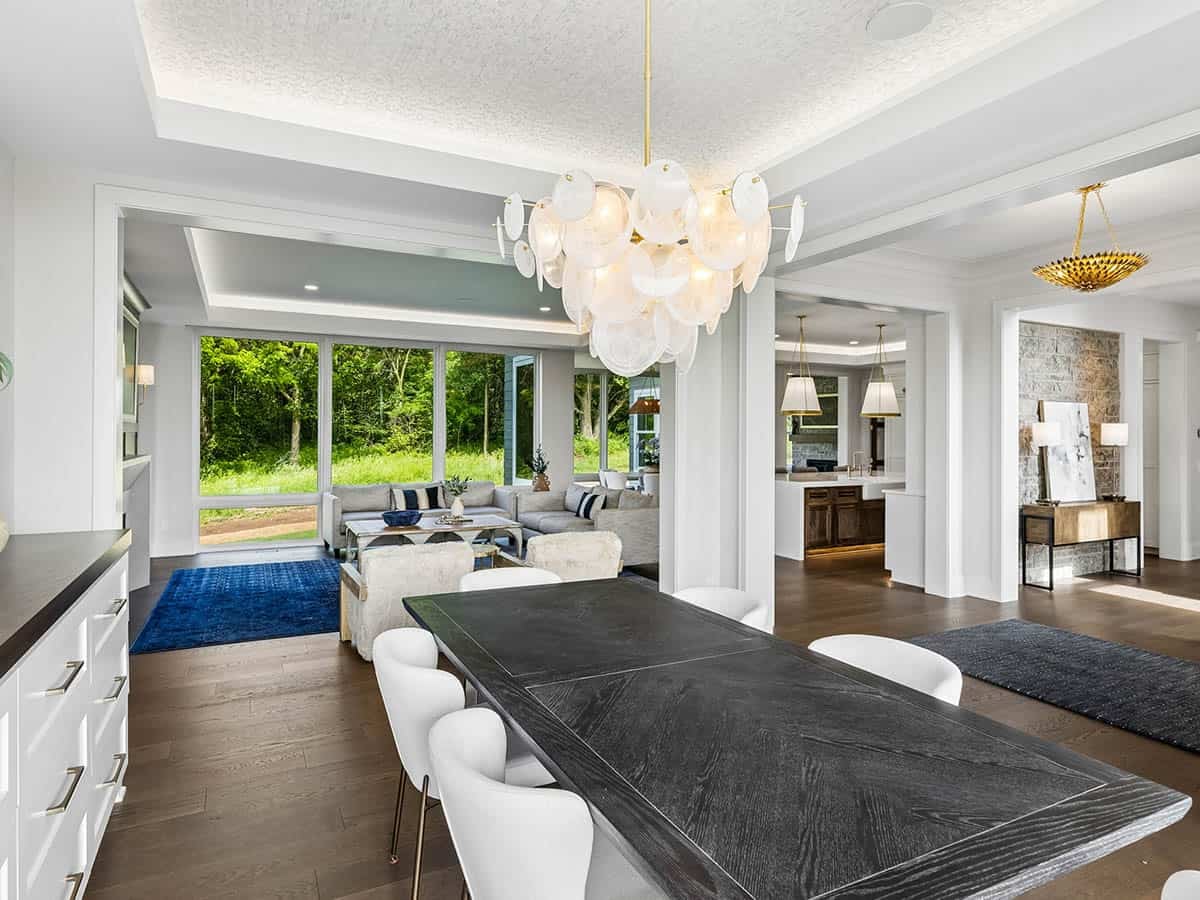 Open dining and living area with bubble chandelier and stone wall