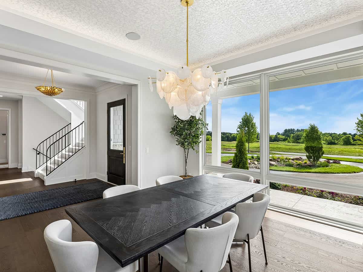 Dining room with staircase view and dark front door
