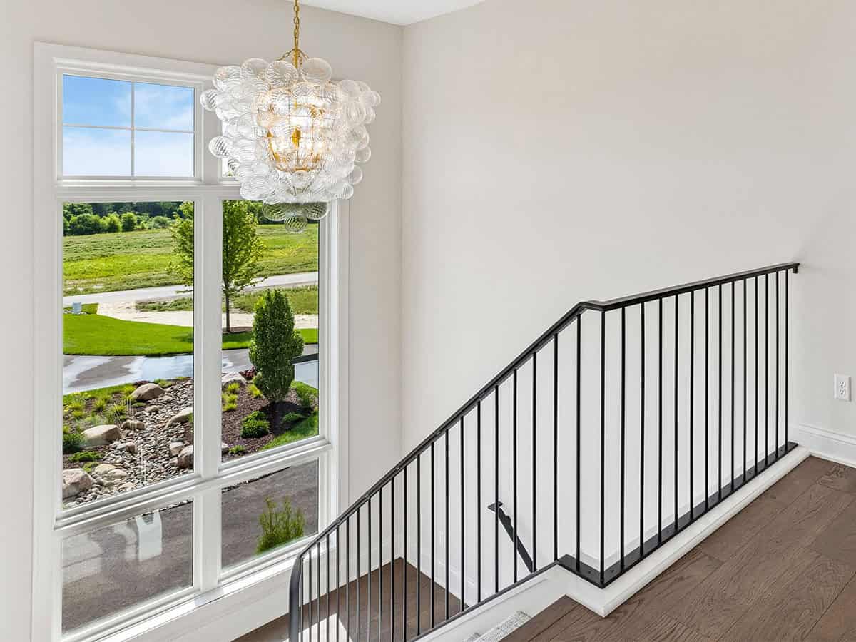 Staircase landing with bubble glass chandelier and iron railing