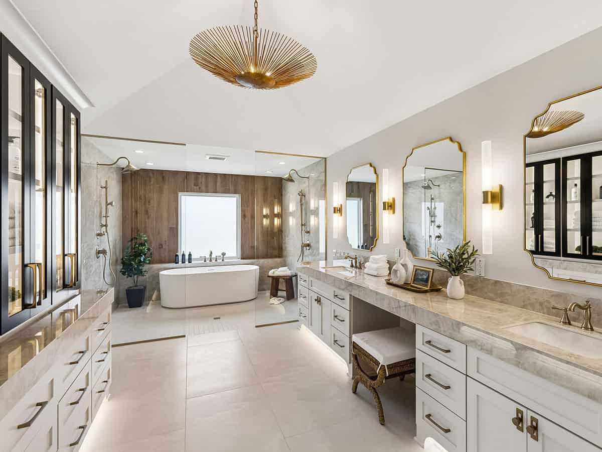 Primary bathroom with freestanding tub, double vanity, and starburst chandelier