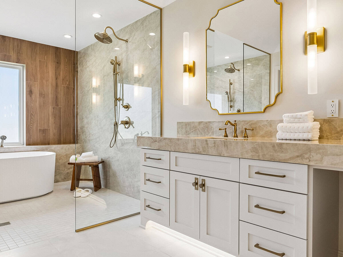 Bathroom vanity with scalloped gold mirror and marble countertop