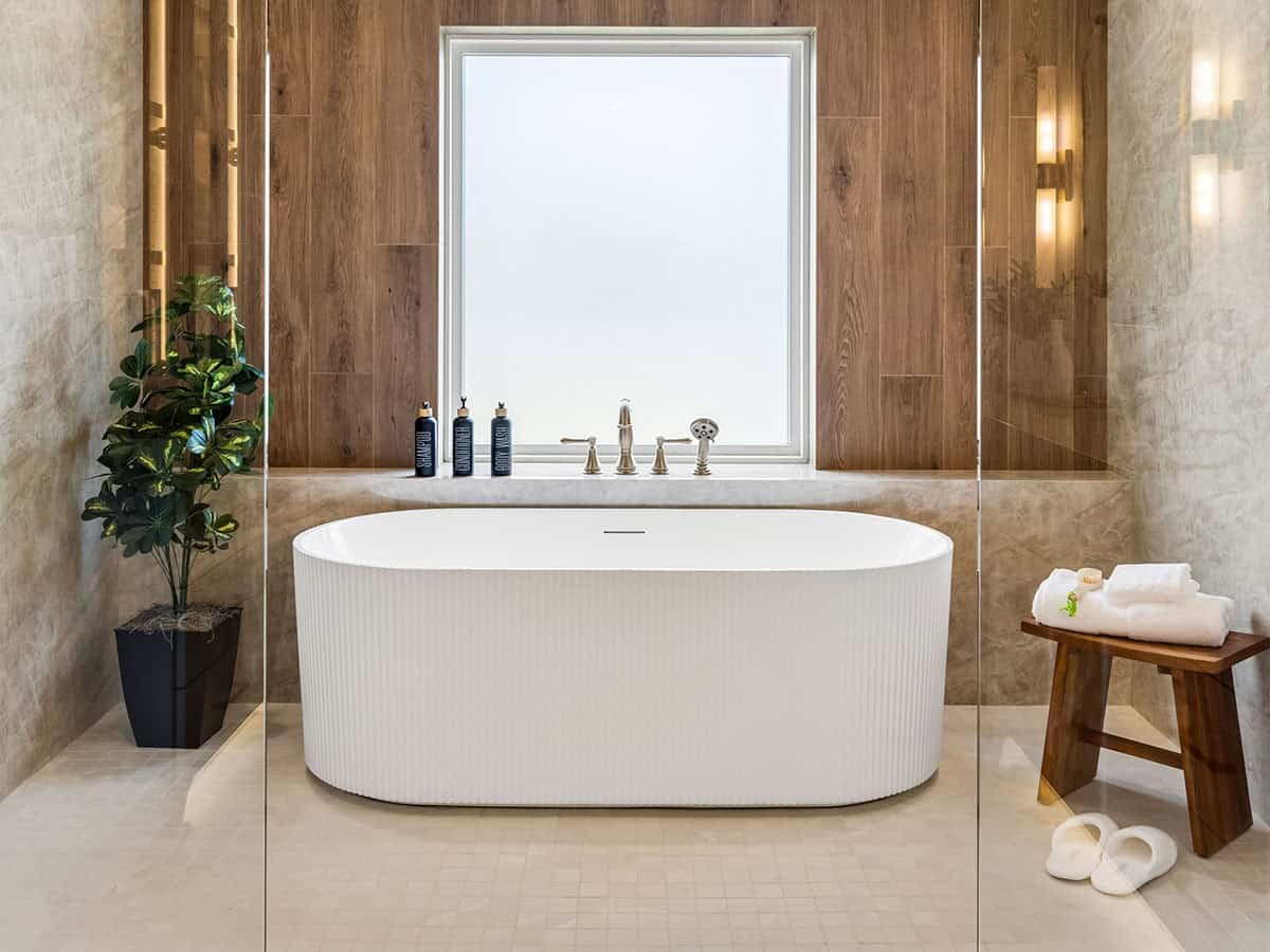 Close-up of freestanding ribbed soaking tub under window