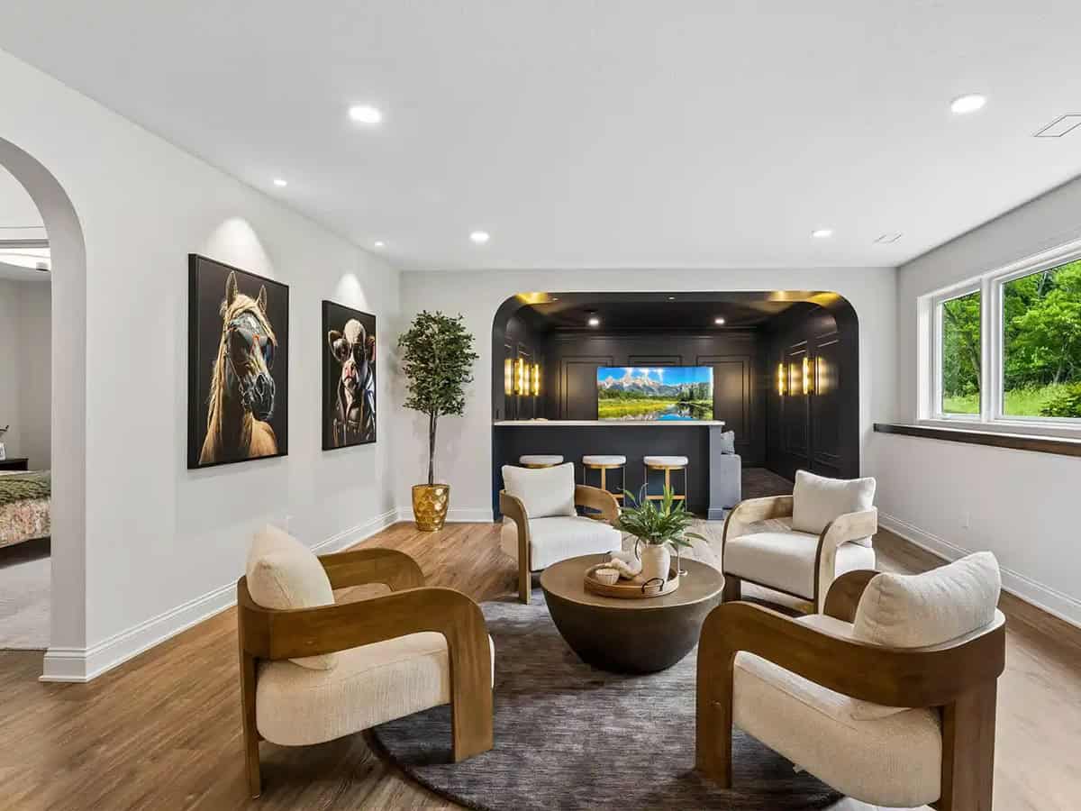Lower-level lounge with horse and cow portraits and wet bar beyond