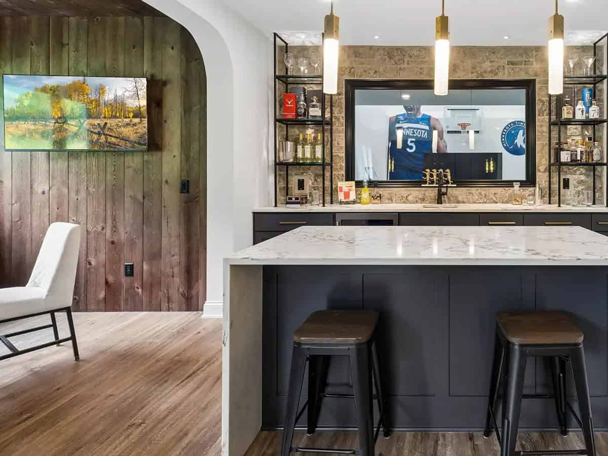 Bar area with stone backsplash mirror and basketball game on TV