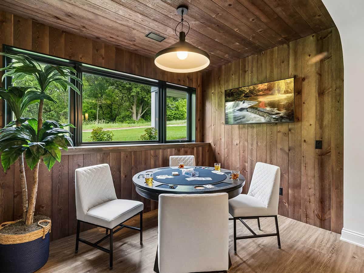 Wood-paneled game nook with round poker table and pendant light