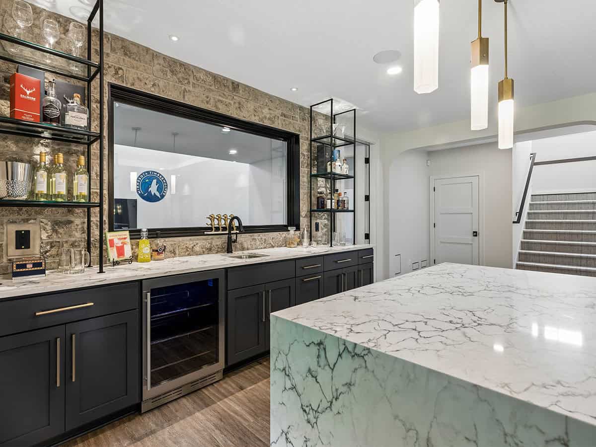 Lower-level bar counter with stone backsplash and Timberwolves window decal