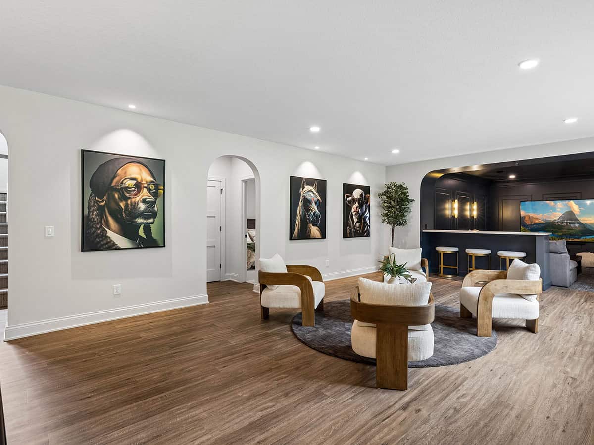 Lower-level lounge with framed dog and animal portraits on wall