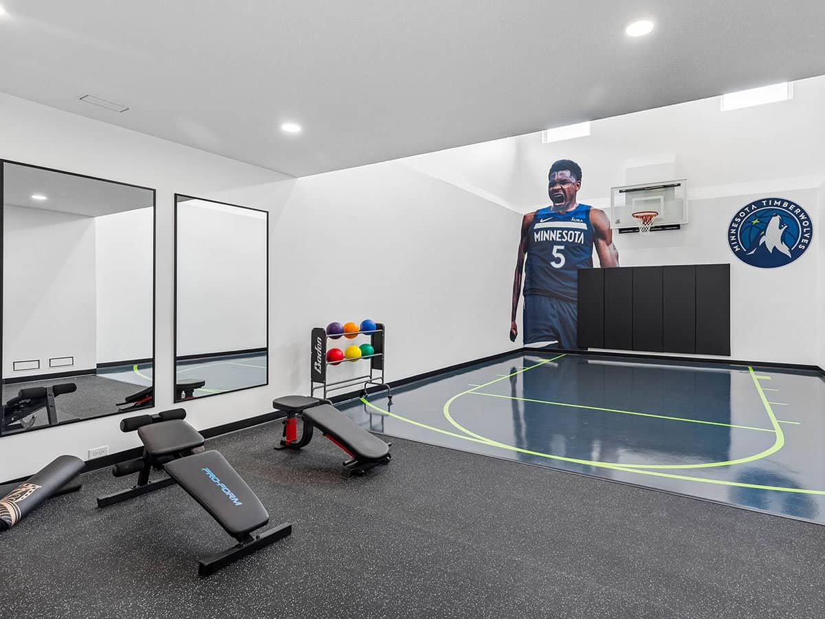 Home gym with mini basketball court and Timberwolves player mural