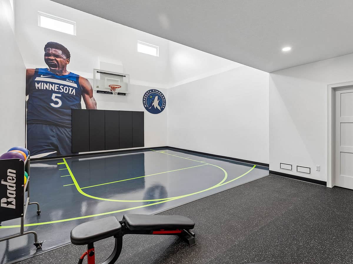 Wide view of indoor sport court with weight bench in foreground