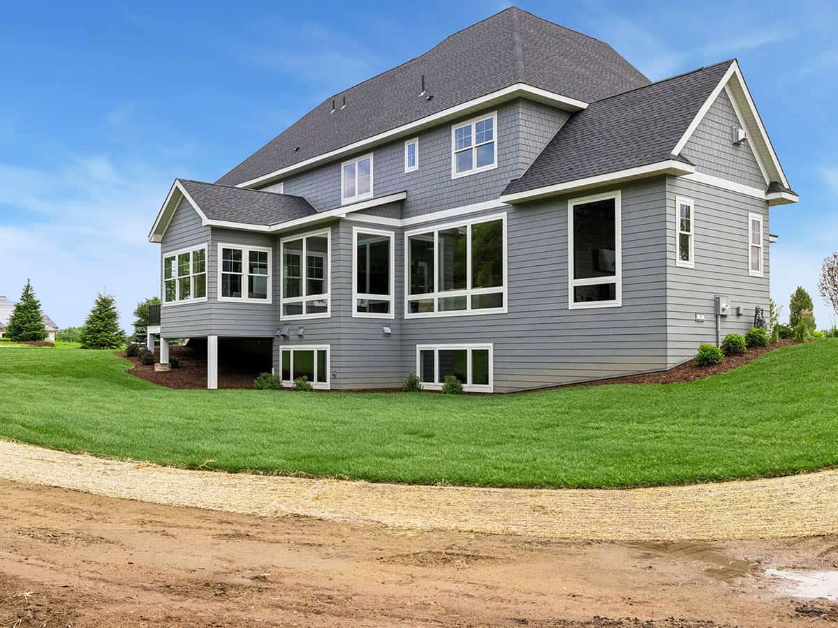 Rear exterior of gray house with walkout lower level and screened porch