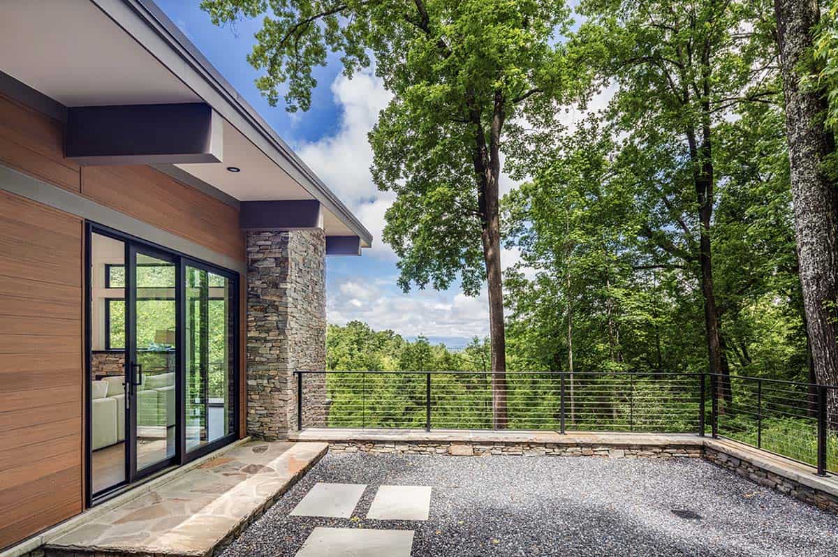 Exterior patio area with gravel and stone pavers overlooking tree-covered hills