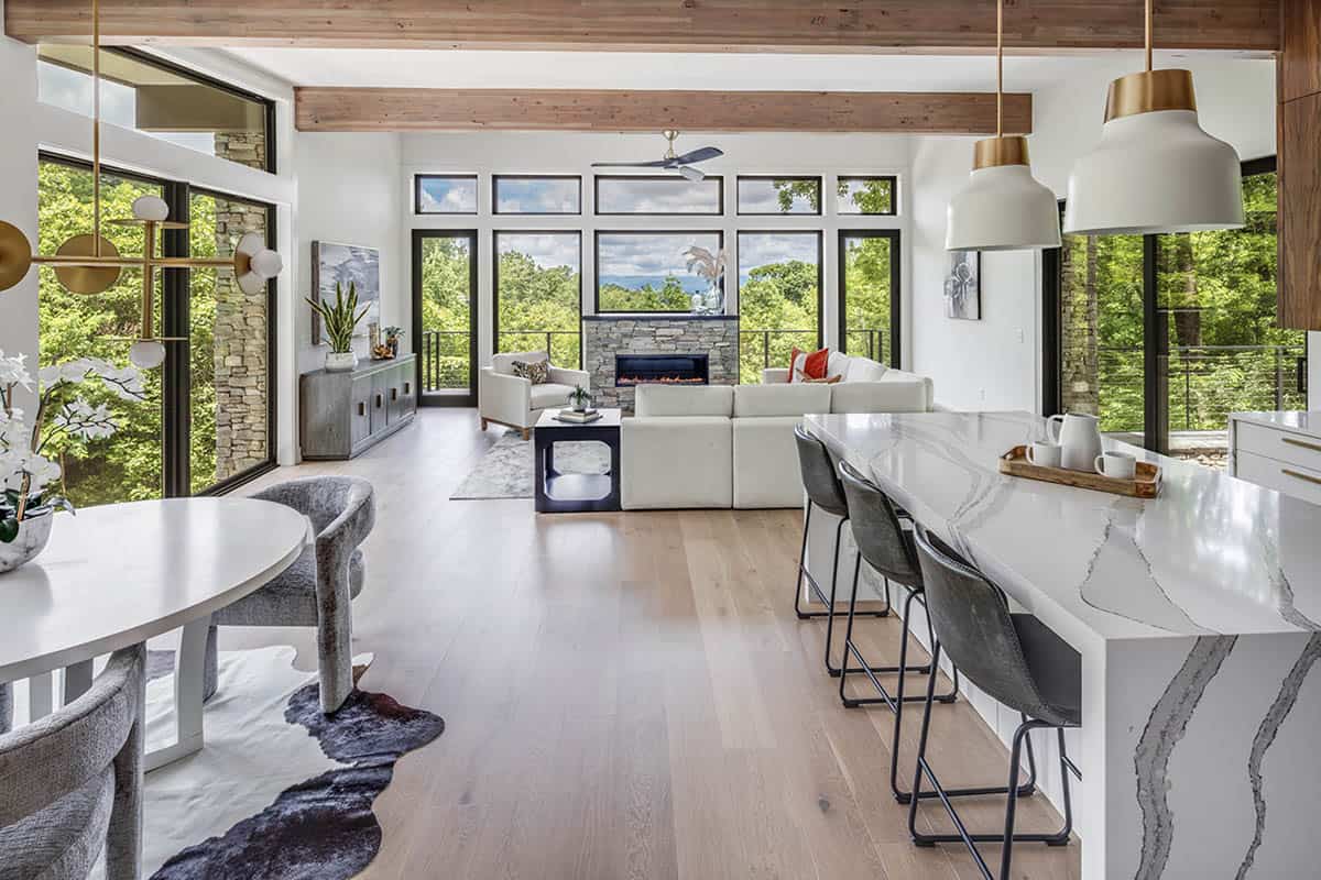Open-concept living, dining, and kitchen area with floor-to-ceiling windows and mountain views