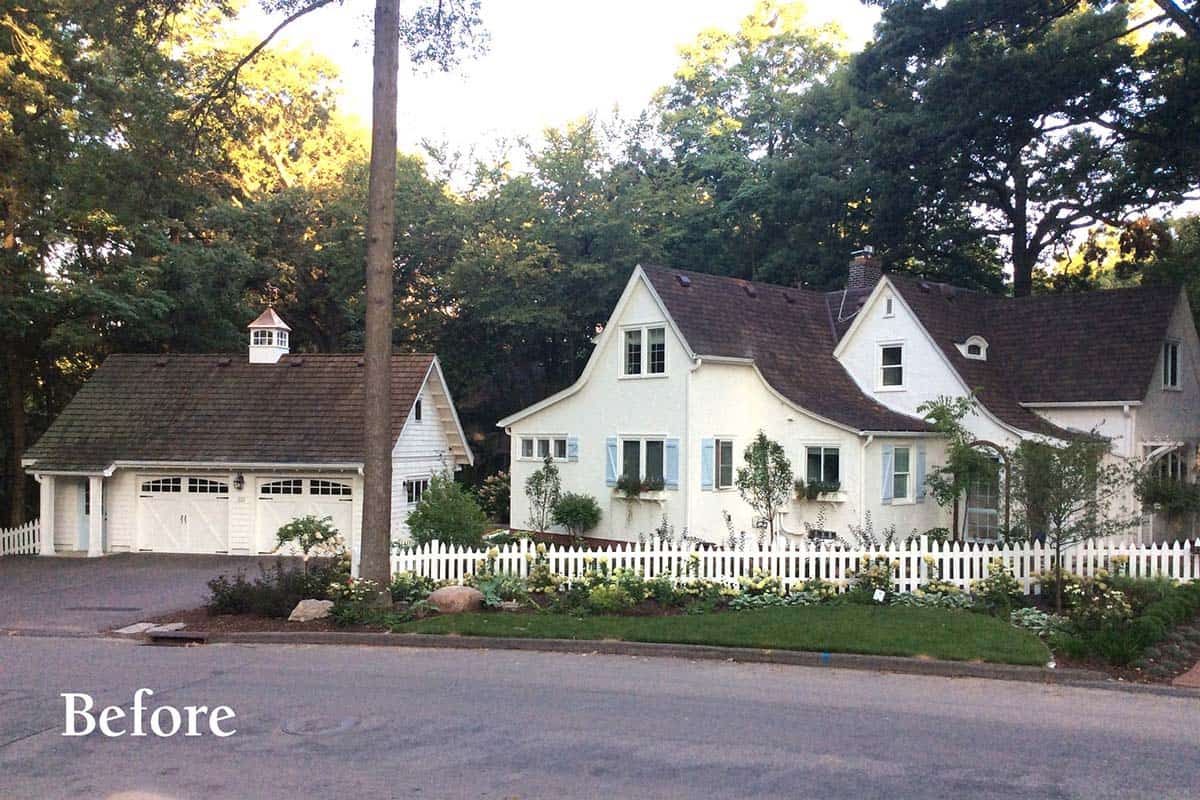 Before renovation: white cottage home street view with blue shutters, detached garage, and sparse front garden, Minnesota