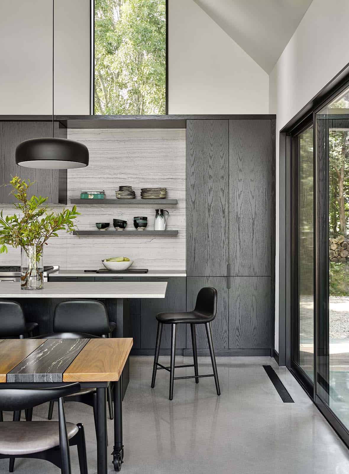 Kitchen and dining area with dark wood cabinetry, marble backsplash, and floating shelves