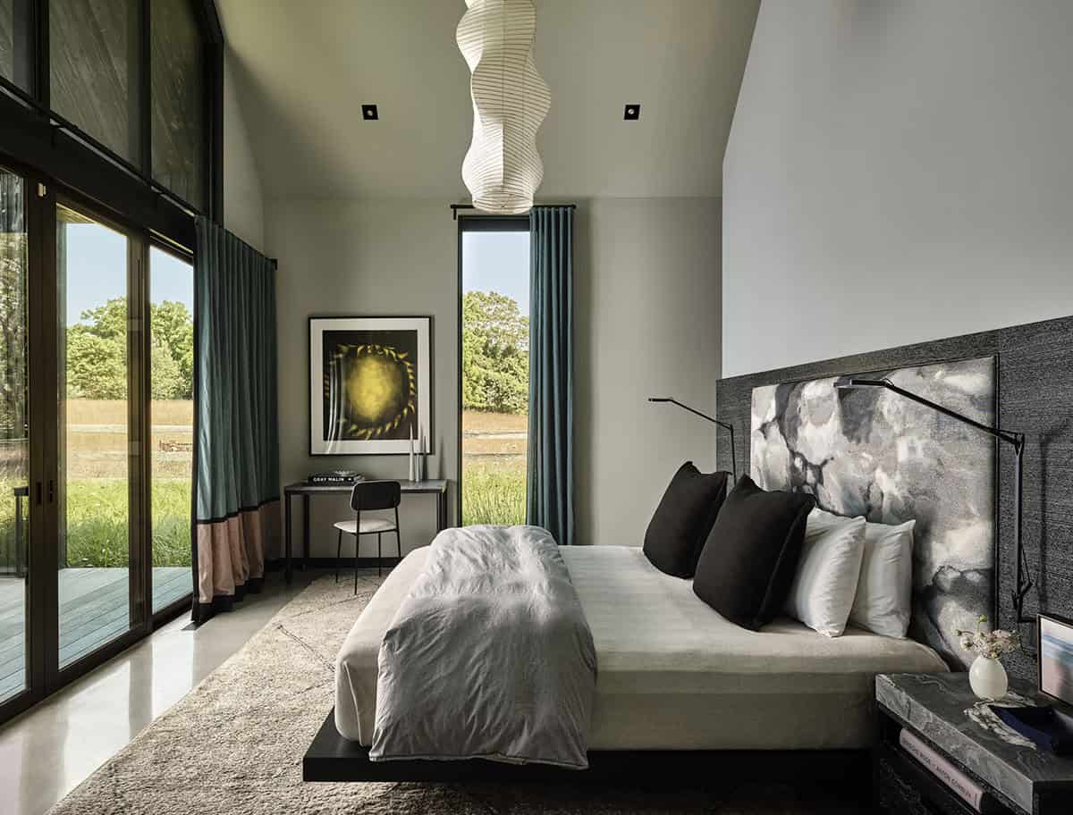 Bedroom with platform bed, gray marble headboard, teal curtains, and floor-to-ceiling windows