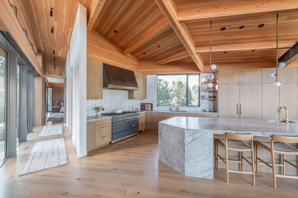 White oak kitchen cabinets with Lacanche range and curved marble island