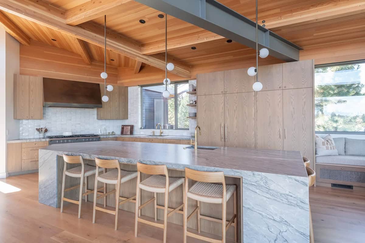 Kitchen island with waterfall marble countertop and white oak cabinetry