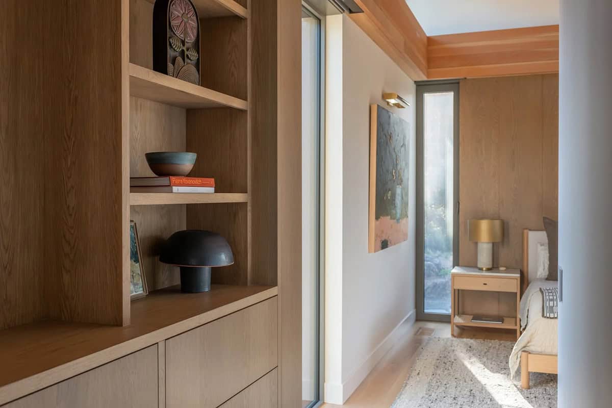Built-in white oak bookcase with hallway leading to bedroom
