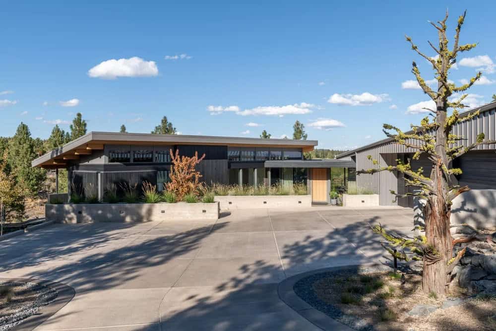 Modern high desert home exterior with dark wood siding and flat roofline