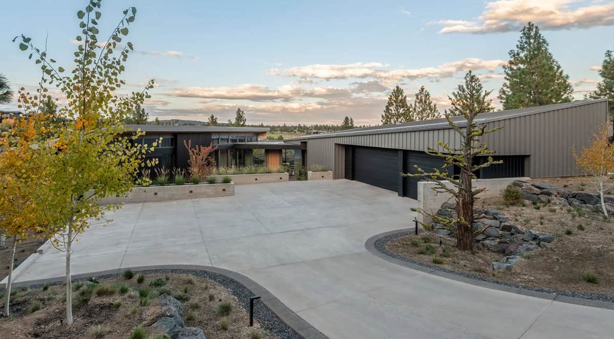 Home exterior at dusk with dark siding, metal roof, and quaking aspen trees