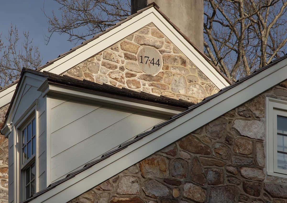 Close-up of stone gable with carved "1744" date stone below chimney