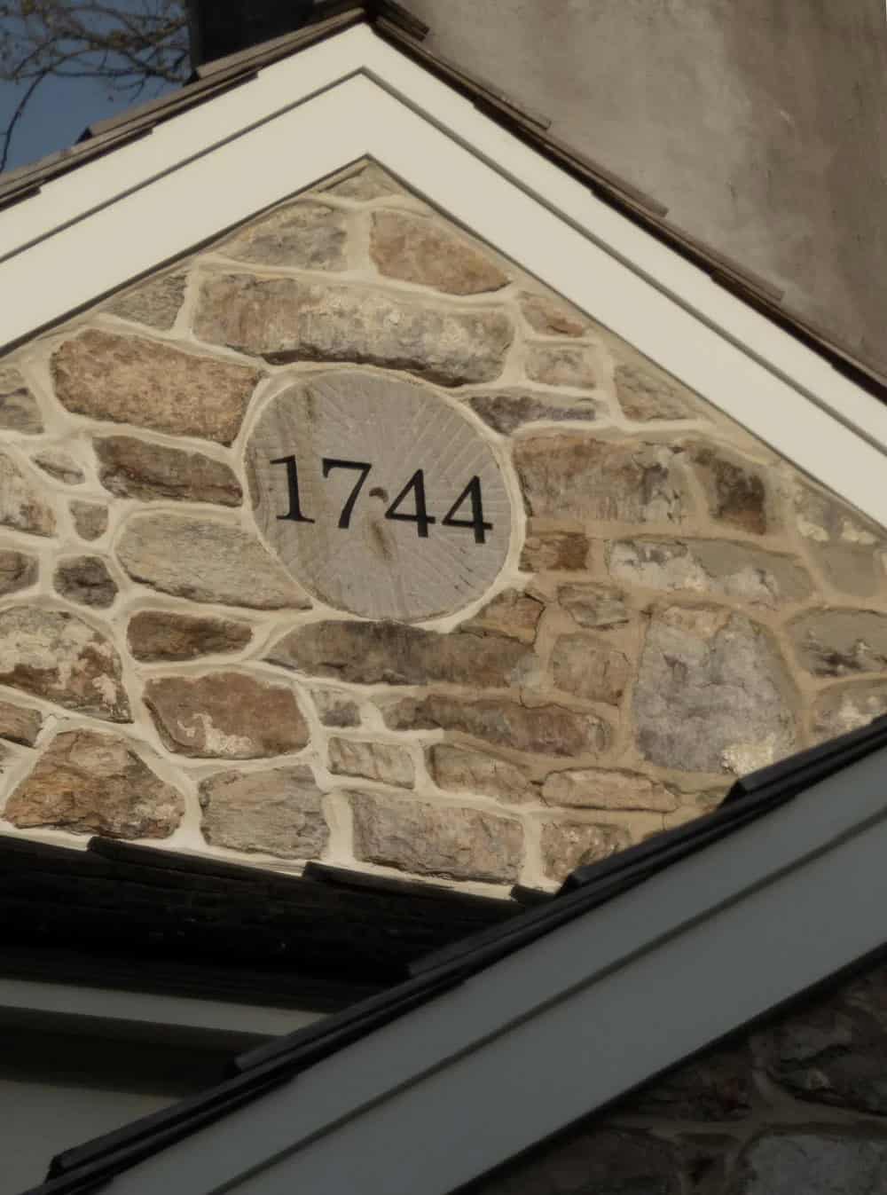 Detail of round stone medallion carved with "1744" set into gable stonework