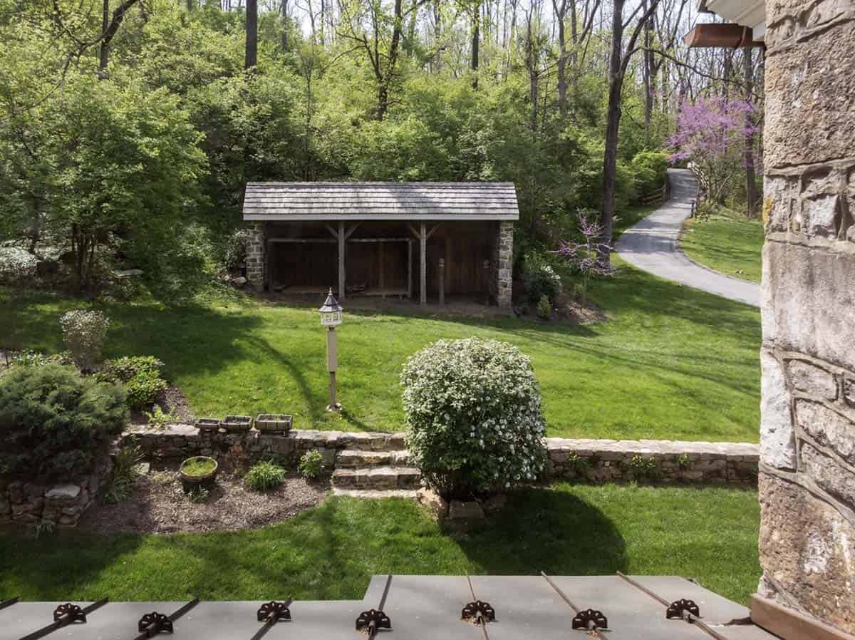 View from porch of stone-and-timber pavilion across a manicured lawn