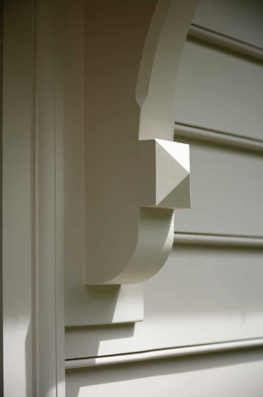 Close-up of white painted wood cornice bracket detail on house trim