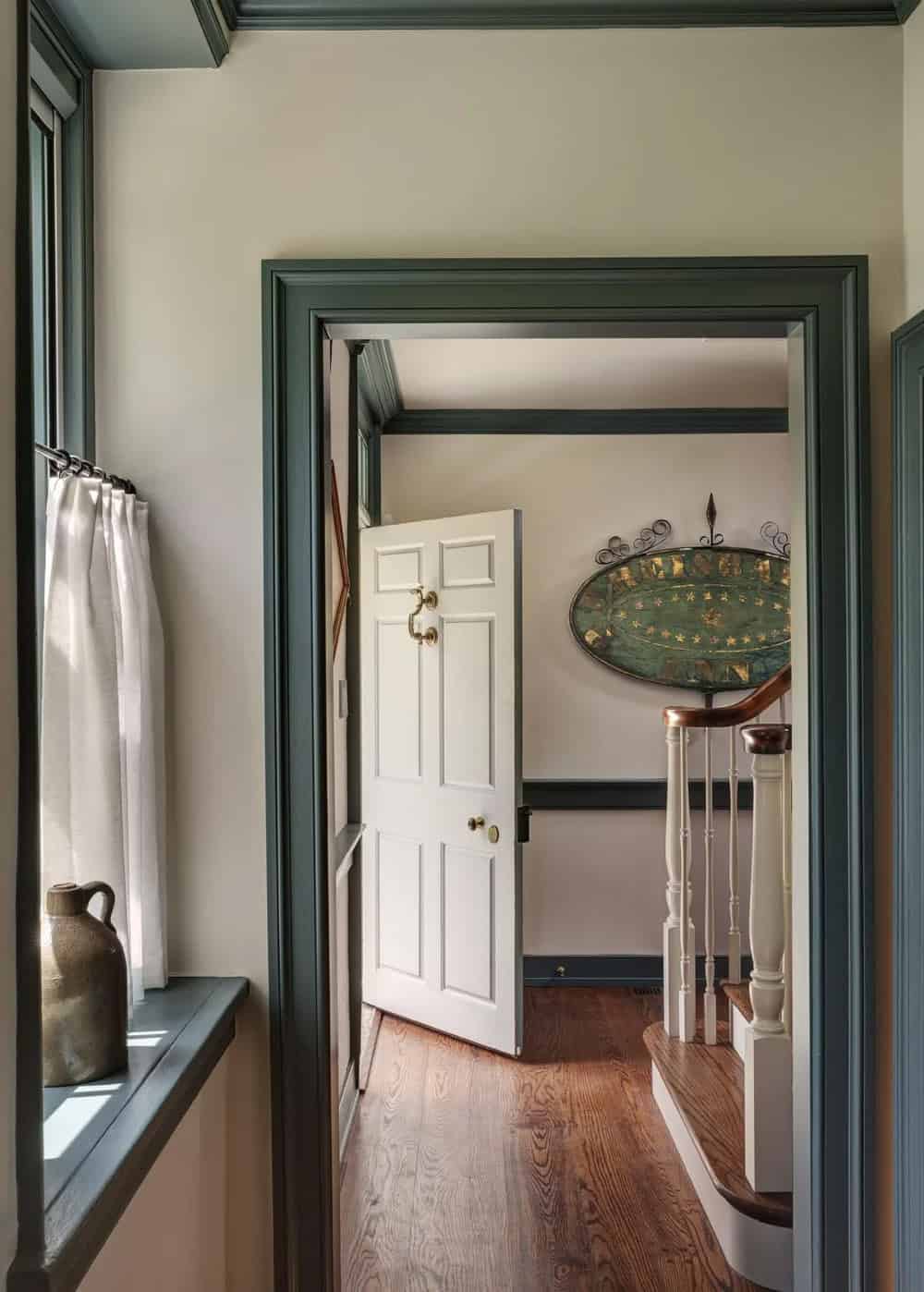 Hallway view through doorway to staircase with antique painted tavern sign
