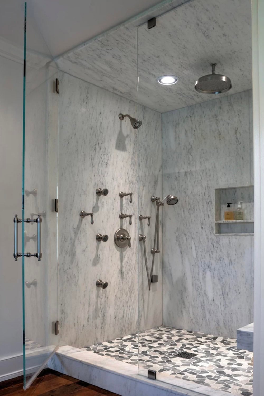 Marble-tiled walk-in shower with multiple body jets and rain showerhead