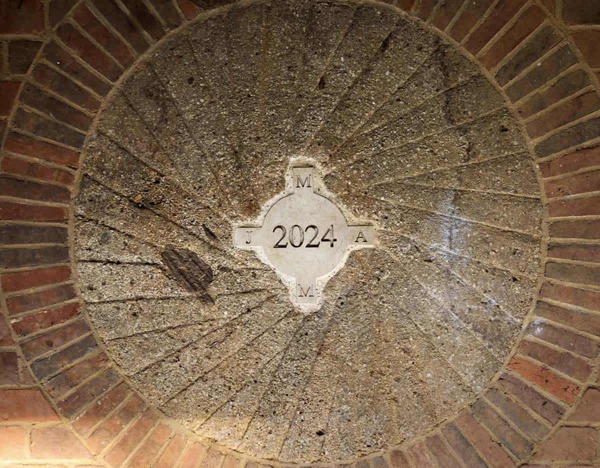 Compass-pattern stone medallion engraved "2024" set into a brick floor