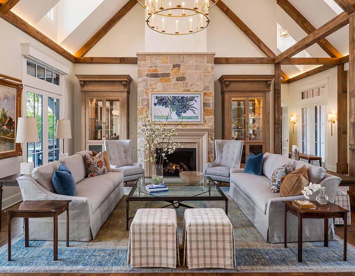 Living room with vaulted beamed ceiling, twin sofas, and stone fireplace