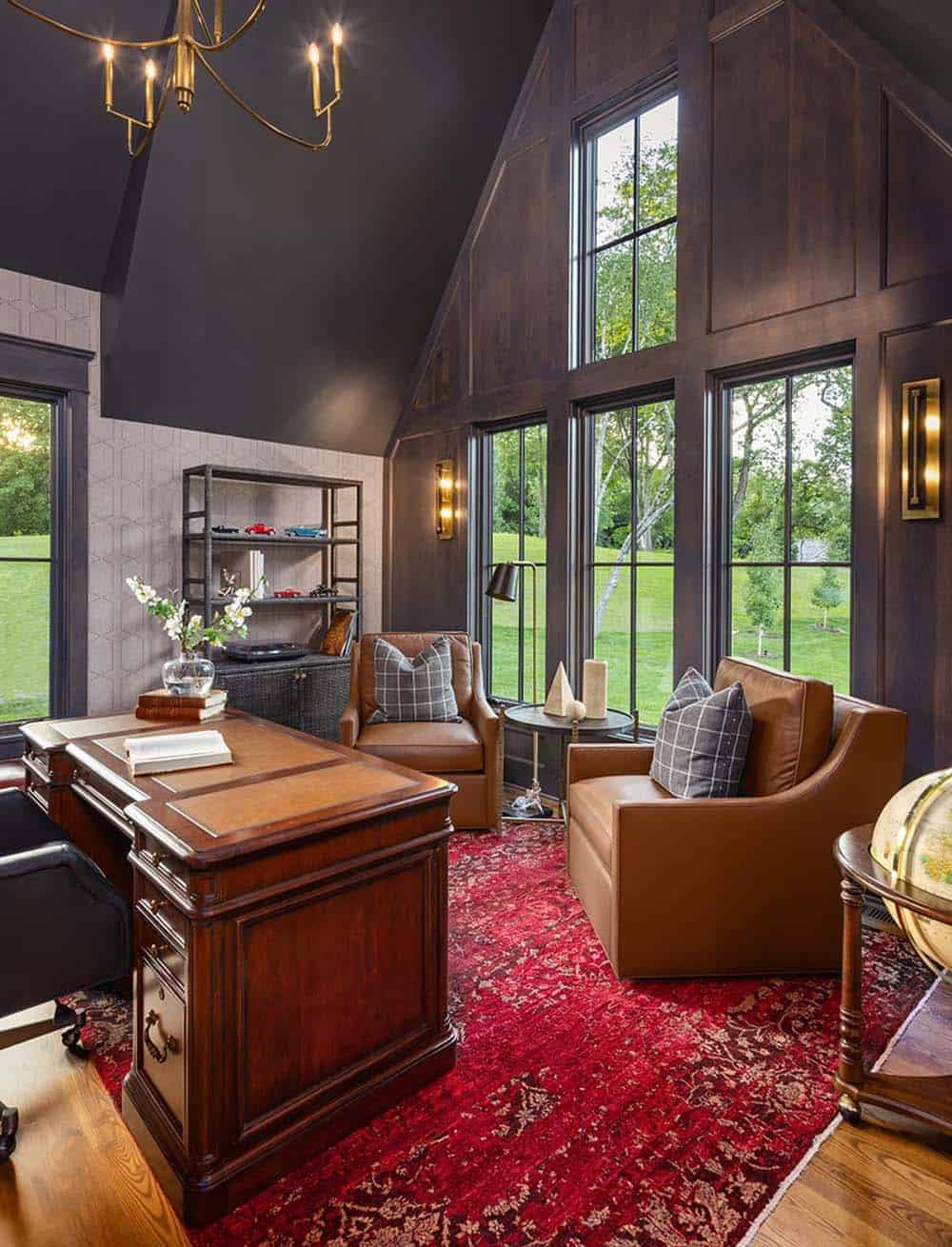 Home office with dark wood paneling, leather chairs, and red patterned rug