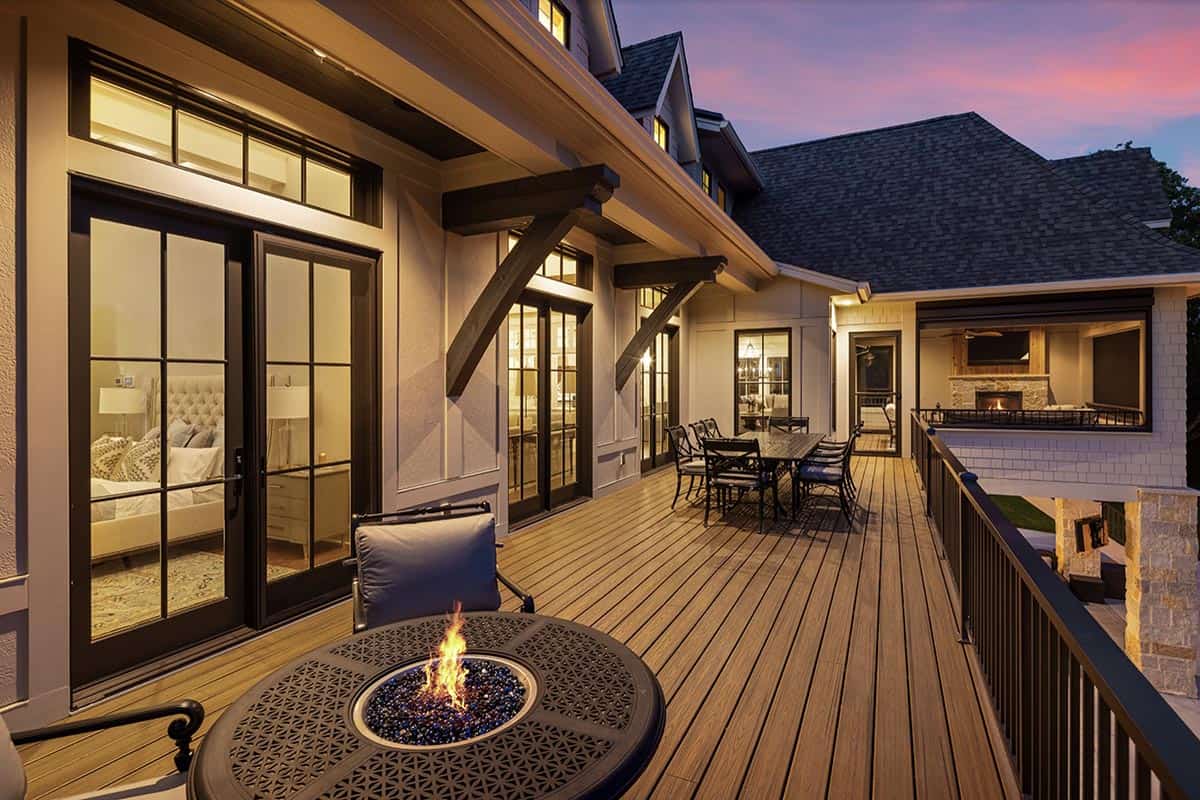 Upper deck at dusk with fire table, dining set, and bedroom French doors