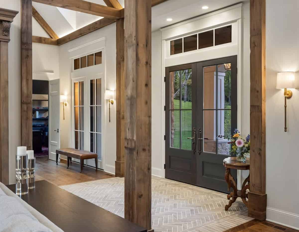 Entryway with herringbone tile floor exposed beams and black French doors