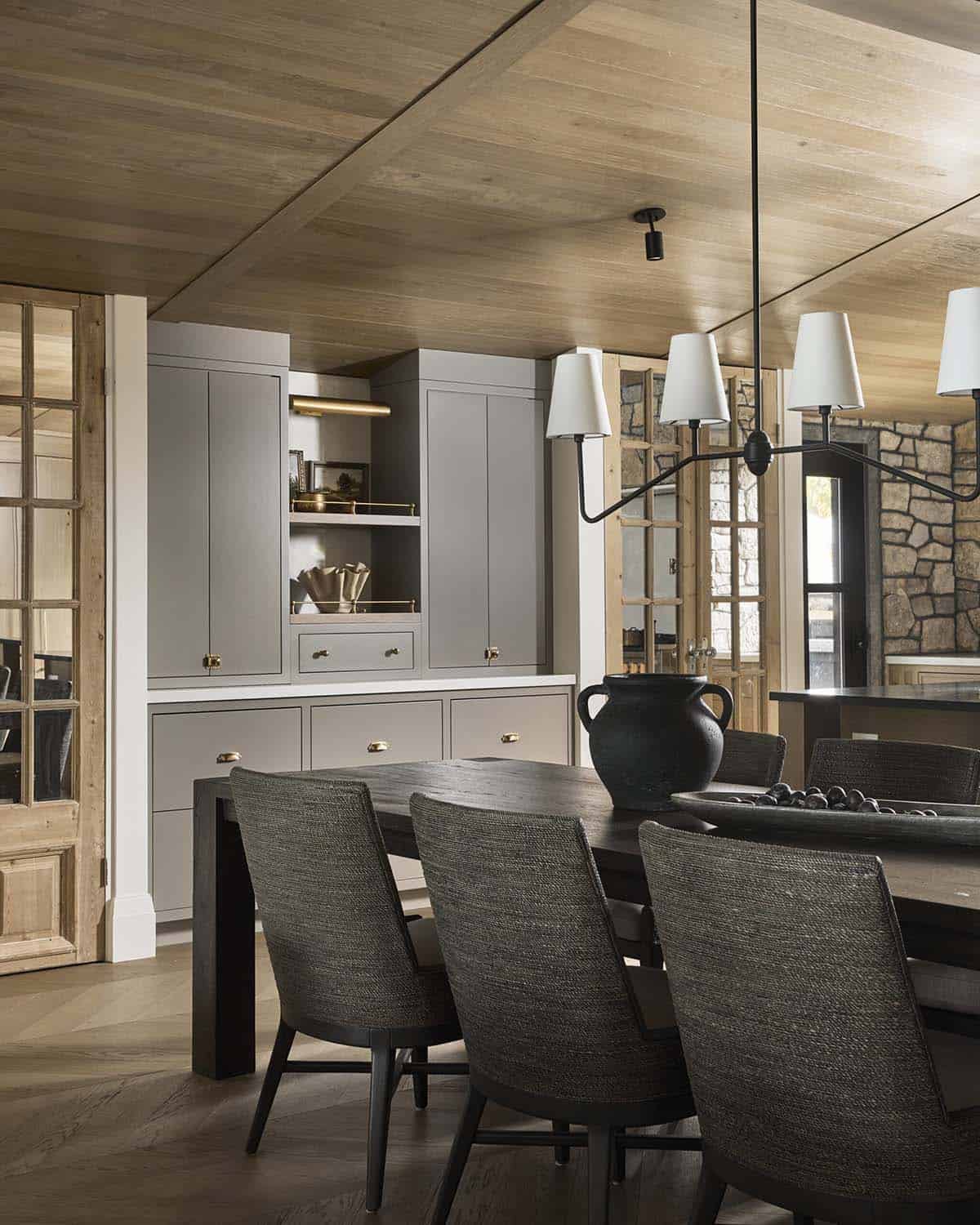 Dining area with dark wood table, woven chairs, and gray built-in china cabinet