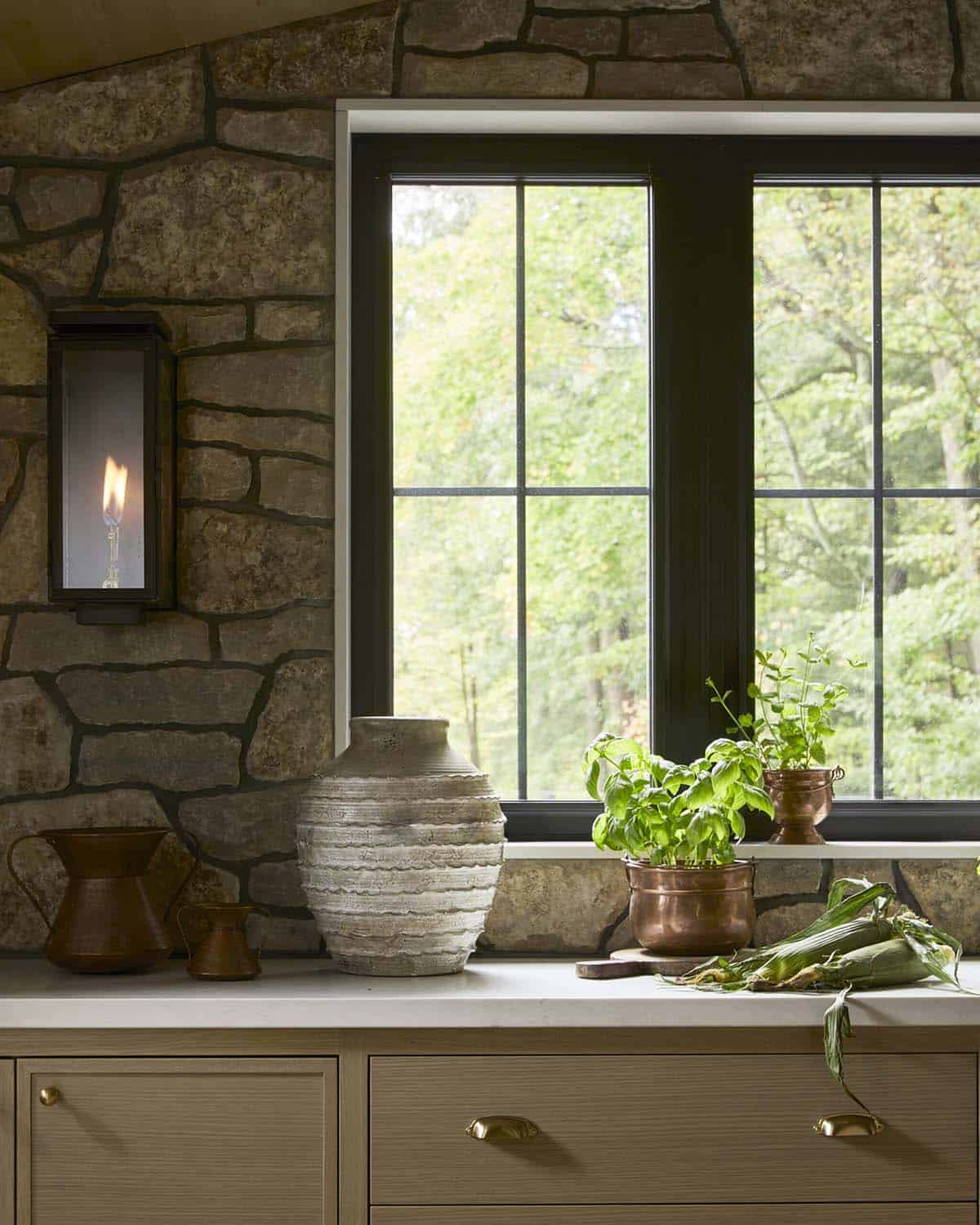 Kitchen window with gas sconce, ceramic vase, and potted basil