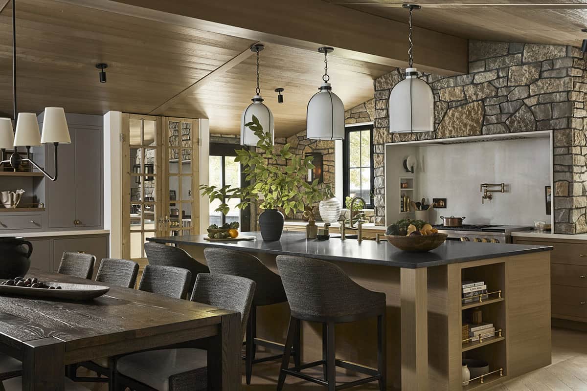 Kitchen and dining area with pendant lighting, island seating, and stone accent wall