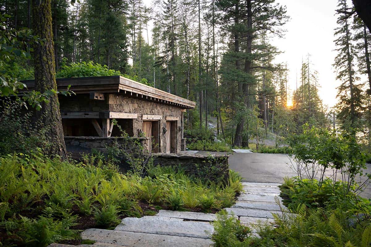 Stone outbuilding with living roof and stone path at dusk