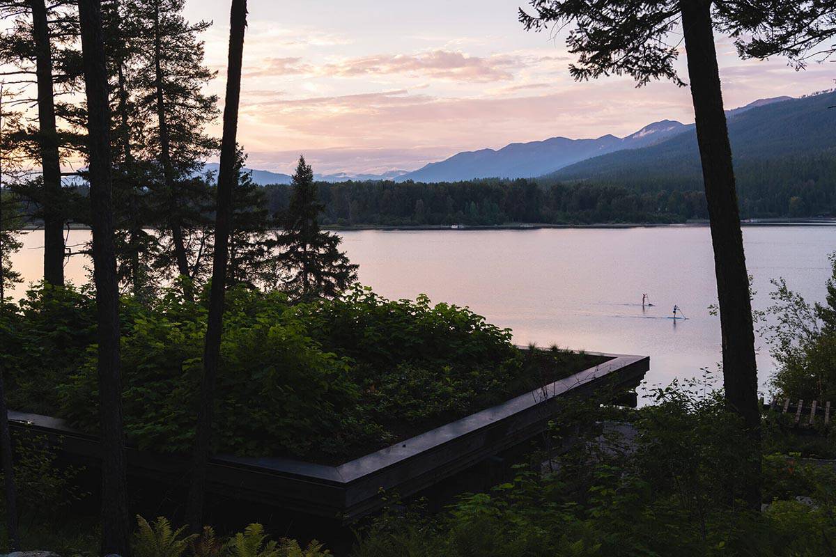 Sunset view of Whitefish Lake with mountains and paddleboarders