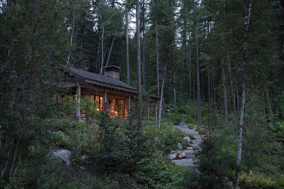 Illuminated log cabin glowing at dusk in the forest