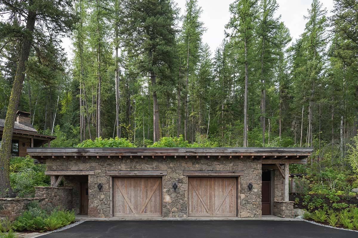 Stone outbuilding with living roof and stone path at dusk