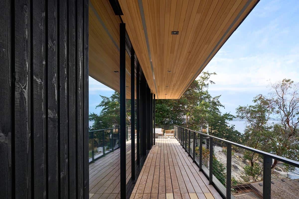 Wraparound deck of Layer House with cedar-lined overhang framing views of the inlet