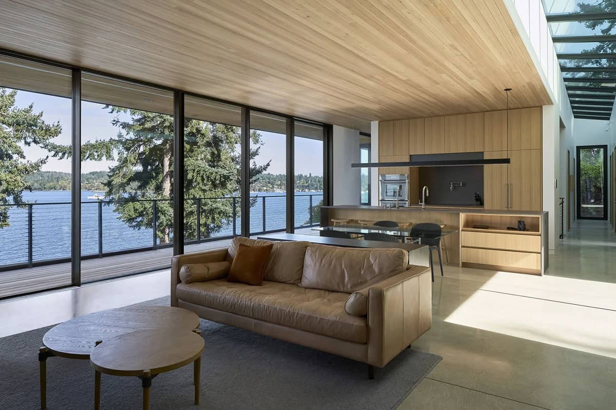 Open-plan living and dining area in Layer House with floor-to-ceiling inlet views