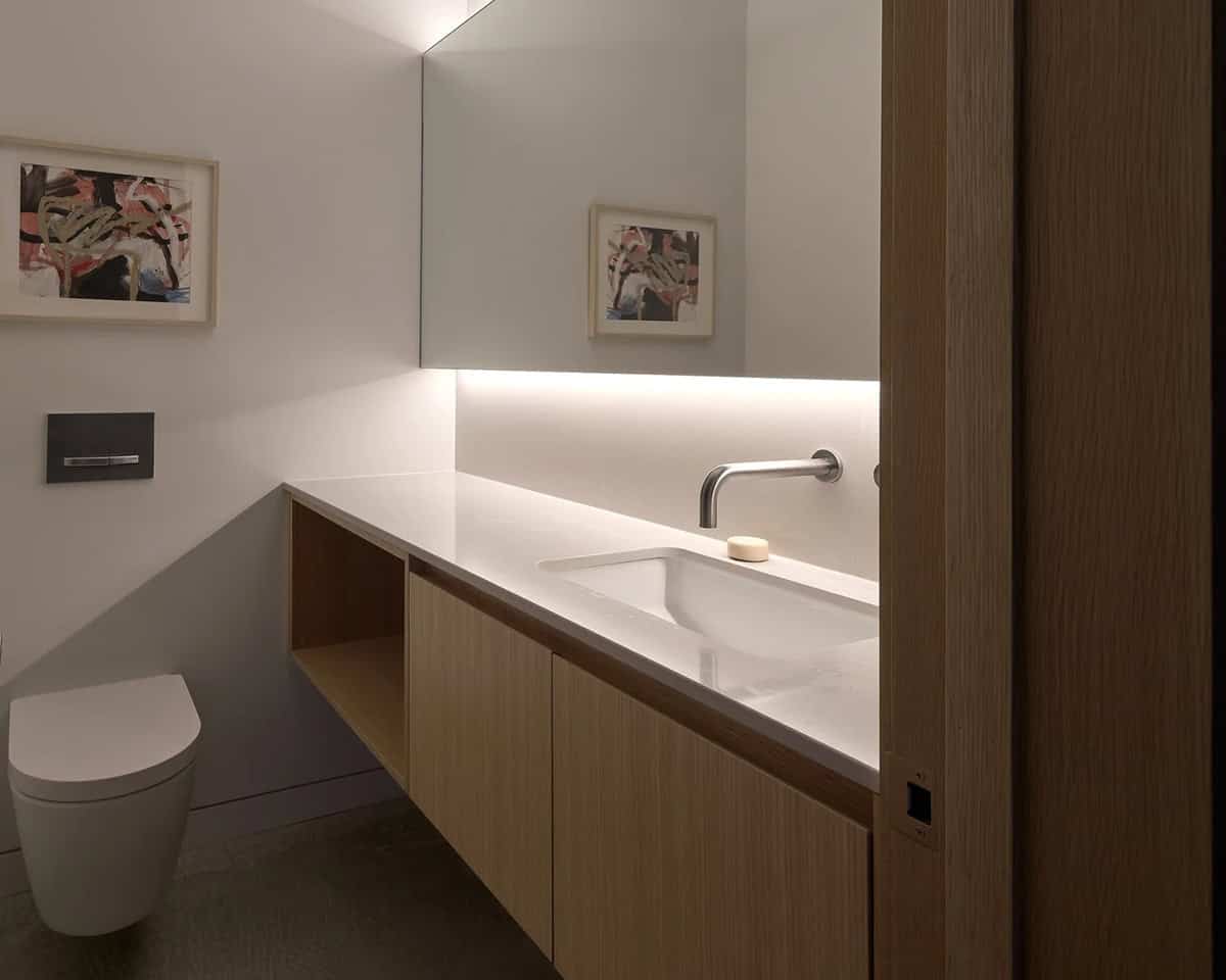 Powder room in Layer House with floating oak vanity and abstract artwork