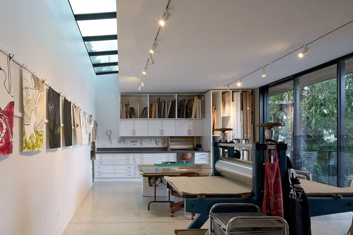 Art studio in Layer House's accessory building with printmaking press and skylight