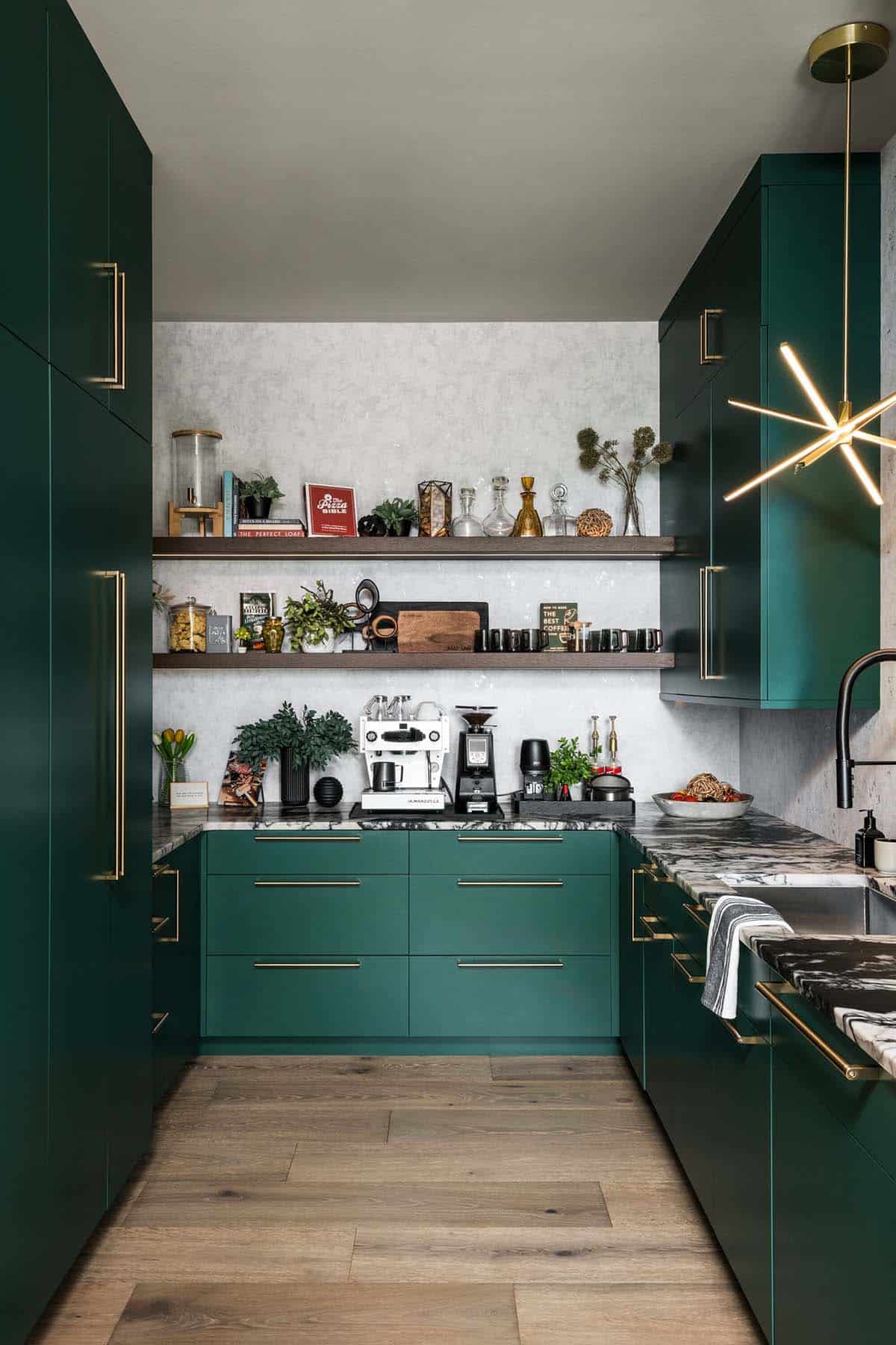 Green cabinetry kitchen nook with open shelving and starburst brass pendant light